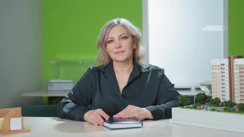 Professional Woman at Desk with Building Model