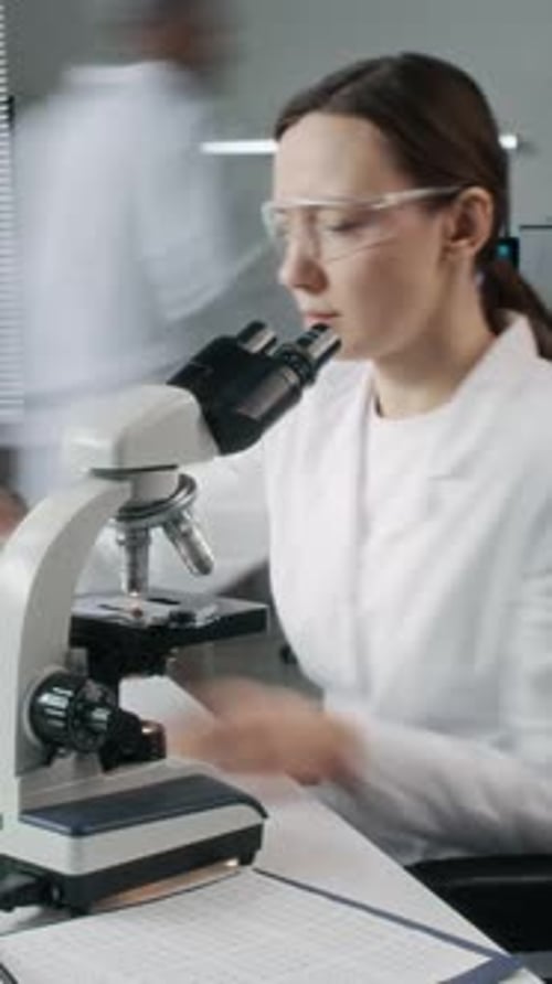 Woman Using Microscope in Lab for Scientific Research