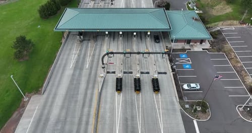 American flag at interstate toll plaza. EZ Pass electronically collects fare from vehicle drivers. A
