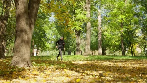 A Man Jogs in an Autumn Park