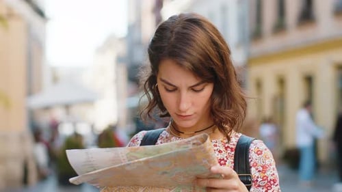 Young Woman Examining a Map in the City