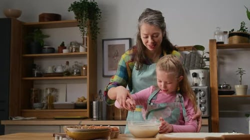 Loving Mother Teaching Young Daughter Make Batter for Muffins