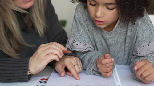 Child Drawing with Adult Indoors During Daytime