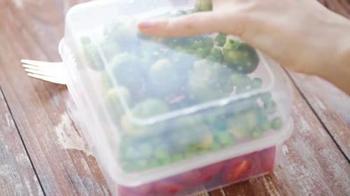 Food, Storage, Dieting and People Concept - Close Up of Woman Opening