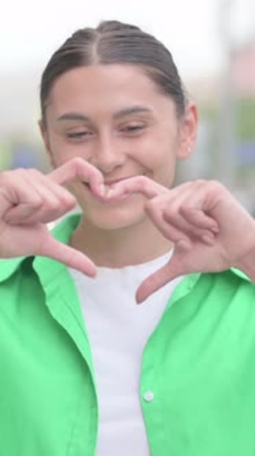 Smiling Woman Making Heart Shape with Hands