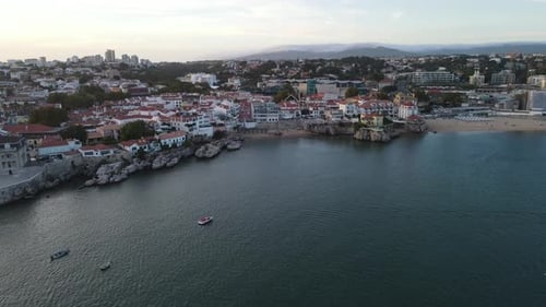 Aerial video flying over the coastline in Cascais, Portugal, sunset