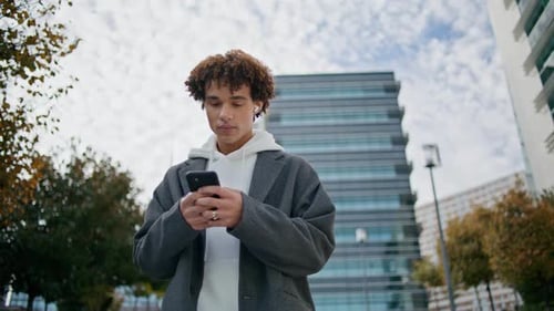 Curly Teenager Typing Smartphone at Street Closeup Young Man Listening Music