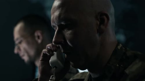 Officer Talking on Landline Phone, Colleague Analyzing Data in Command Center