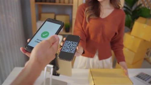 Close up hands of customer using mobile phone paying for goods package.