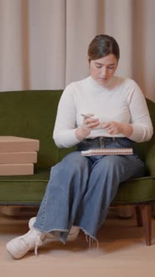 Woman Writing in Notebook on Green Couch