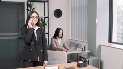 Smiling Woman Talking on Phone in Office