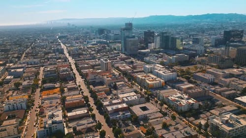 Los Angeles architecture on beautiful sunny daytime. Hazy mountains at backdrop of blue skies.