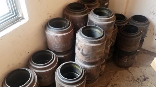 A storage area is depicted filled with several large cylindrical objects - train wheelset bearings