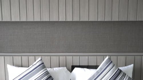 Modern Bed With White Sheets and Striped Pillows