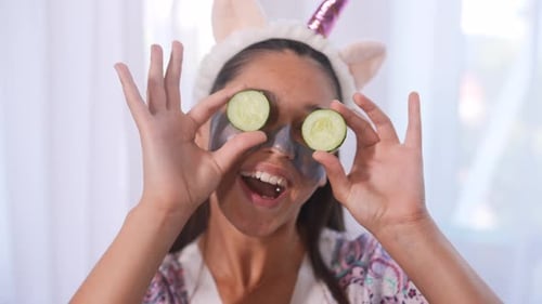 Funny Smiling Spa Woman with Fresh Facial Mask Hold Cucumbers