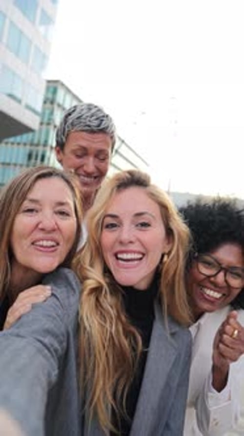 Smiling Women Posing for Selfie in Front of Building