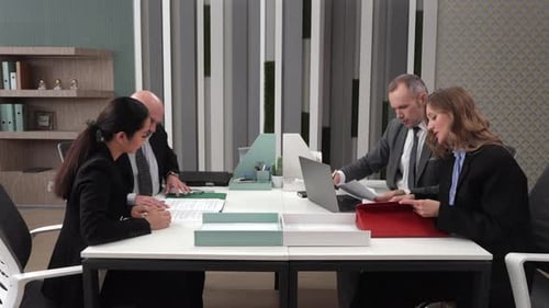 Business Team Meeting and Reviewing Documents in Office