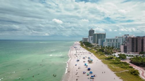 Aerial View of Oceanfront City Skyline: Modern Skyscraper Architecture, Sandy Beach, Turquoise water