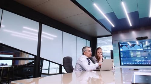 Business Colleagues Discussing Data on Laptop in Conference Room