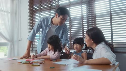 Asian family with children Drawing and painting on table