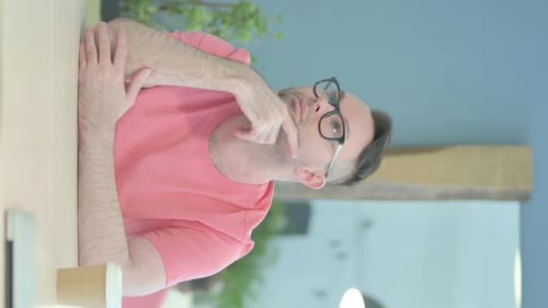 Man with Glasses Thinking Thoughtfully at Table