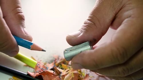 Footage of hands slowly sharpening a pencil and some coloured pencils with a Wedge Pencil Sharpener.