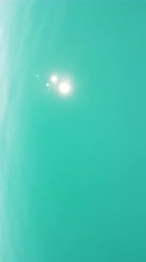 Vertical Aerial View on Sea Water Surface Camera Flies Over Clear Sea Water Sun Glare Abstract