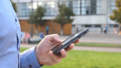 Close Up Hand of Young Businessman Holding and Touching Smartphone