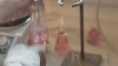 Scientist Conducting Experiment with Pink Liquid in Flask