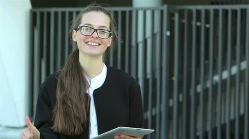Young Adult Woman With Tablet Gives Thumbs Up