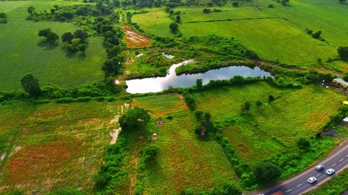 a beautiful lake amidst large land of agricultural farms area upper view