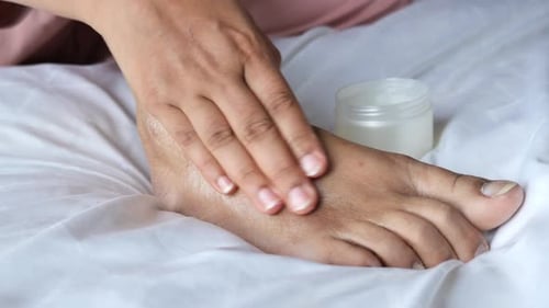 Woman Using Petroleum Jelly on Feet at Home