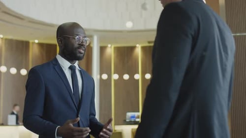 Geschäftspartner geben sich die Hand und reden im Hotel
