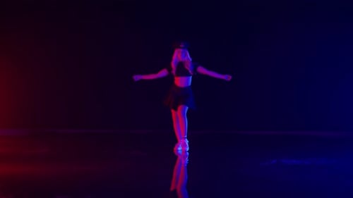 Sexy Young Woman in Policeman Hat Dances in Colorful Stage Lights in Studio