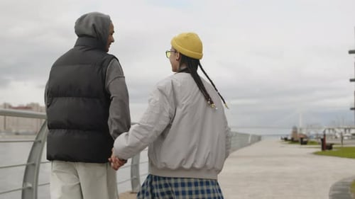 Biracial Hipster Couple Walking on Boardwalk Holding Hands