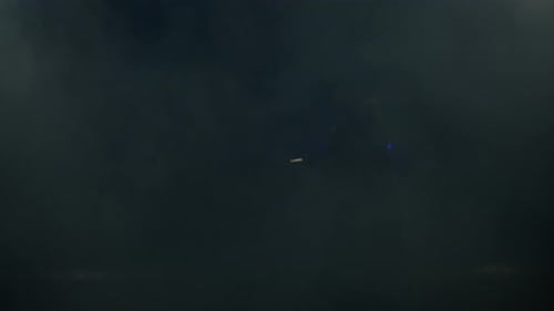 Young Man in Jedi Cosplay Costume with Lightsaber Battle on Black Background in Smoke and Rain Slow