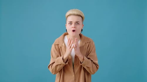 Une femme blonde surprise avec une coupe courte réagit avec surprise