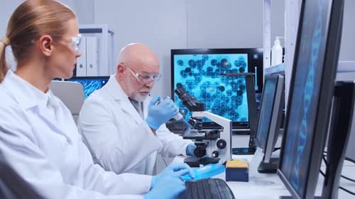 Scientists Work in Lab Using Microscope and Pipette