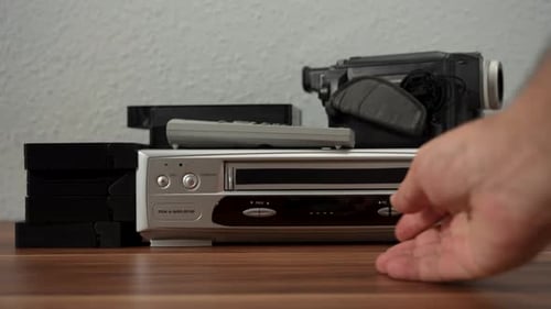 Hand Inserting VHS Tape into VCR