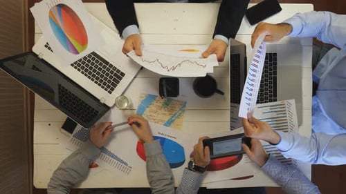 Male and Female Hands of Entrepreneurs Analyzing Financial Graphs at Office Group of Young Coworkers