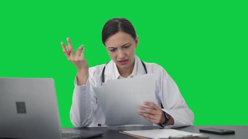 Stressed Indian female doctor explaining medical report to patient Green screen