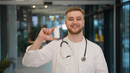 Smiling Doctor Holding Prescription Medication in Hospital