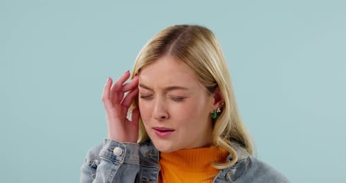 Woman Massaging Temple with Fingers in Studio Shot
