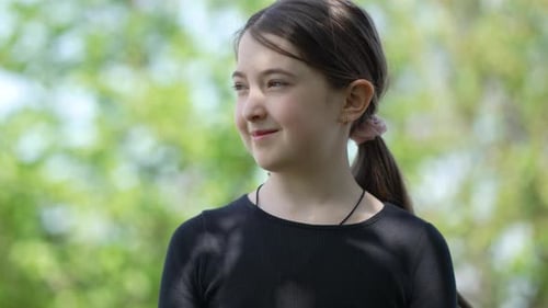 Girl Smiles Gently in Natural Outdoor Setting