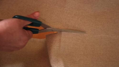 Scissors Cutting Burlap Fabric in a Close Up Shot