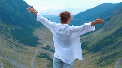 Woman Raising Arms Enjoying Scenic Mountain View
