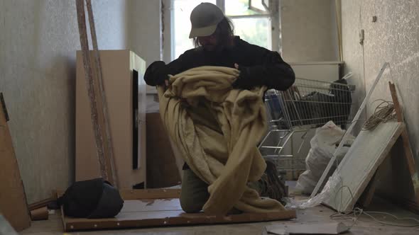 Homeless Poor Man Making His Bed Out of Cardboard Rags and a Blanket in ...