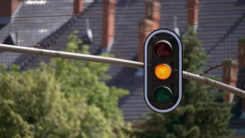 Ampel mit grünen und roten Signalen über der Straße in einem Wohngebiet an einem sonnigen Tag mit
