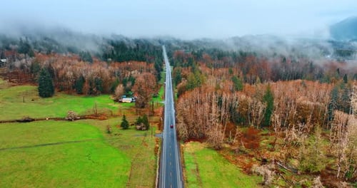 Flying above the straight asphalt road following the red car riding by it