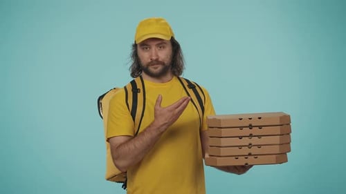 Zusteller in gelber Uniform mit tragbarem Rucksackkühlschrank mit Stapel Pizzakartons und